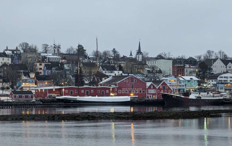 Historic red buildings and boats along the waterfront harbor of Lunenburg, Nova Scotia.