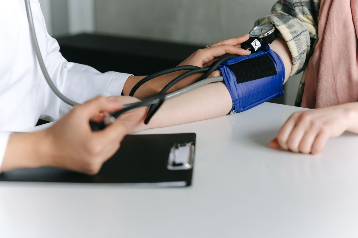 A healthcare provider measuring a patient's blood pressure with a manual cuff.