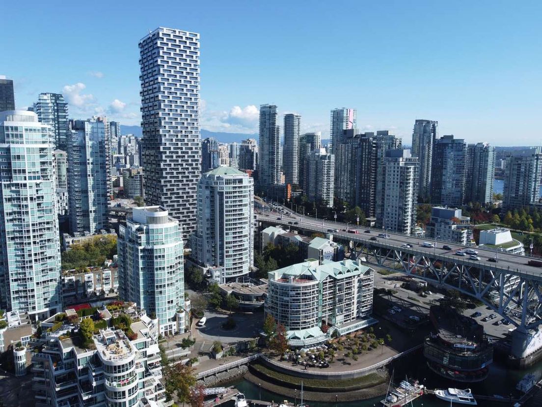 Aerial view of downtown Vancouver skyscrapers and a bridge along the waterfront on a clear day.